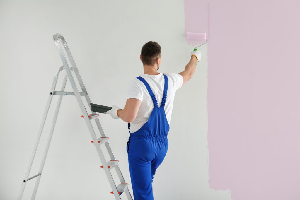 Man painting walls in empty room