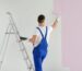 Man painting walls in empty room